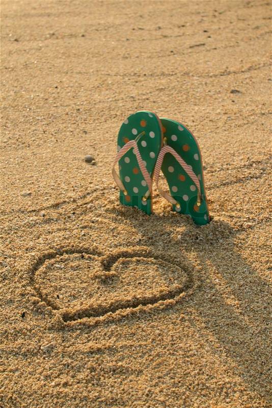 Colorful flip flops and heart shape on white sand beach in vintage style, stock photo