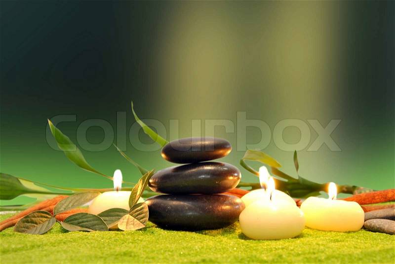 Green leaf with natural water drops candles with colored stones
