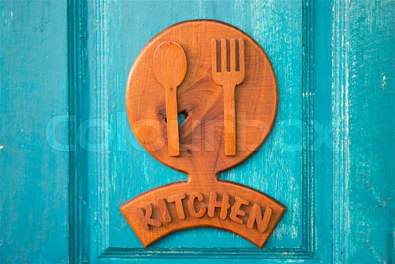 Kitchen wood sign hanging on green door, stock photo