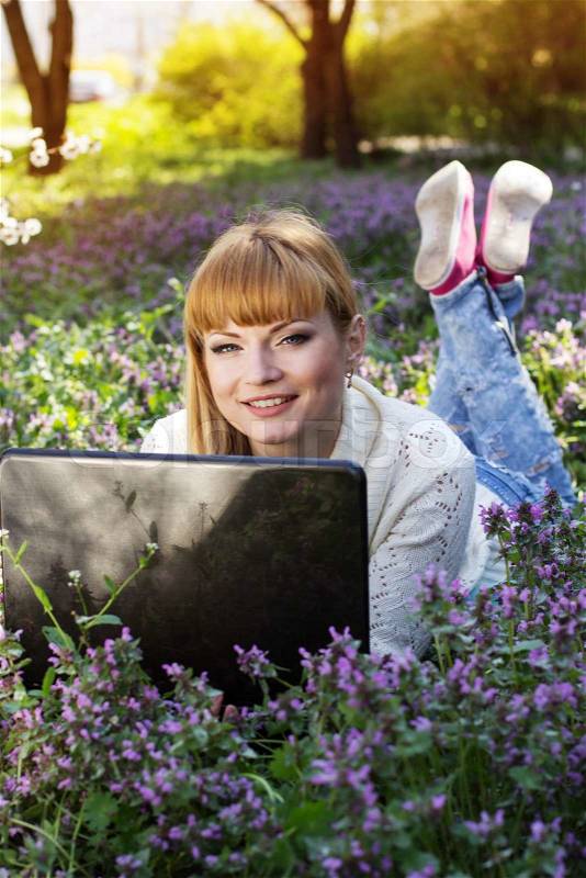 Beautiful woman with a laptop on the nature, stock photo