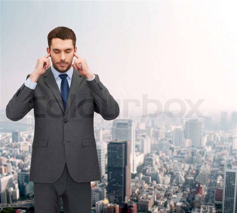 Businss, office and education concept - annoyed businessman covering his ears with his hands, stock photo