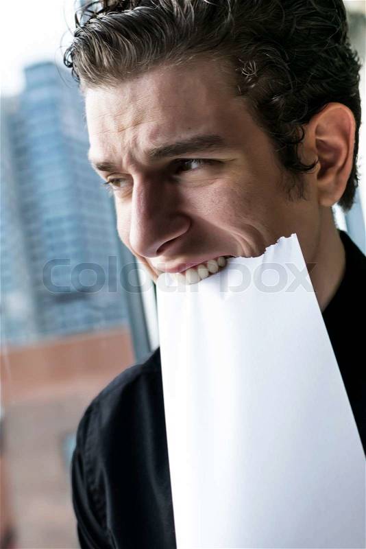 Sad and frustrated business man eating paper, stock photo