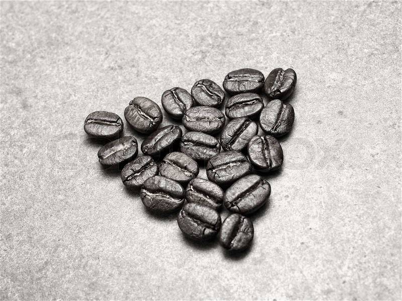 Roasted Coffee Beans on retro texture board, monotone color background, stock photo