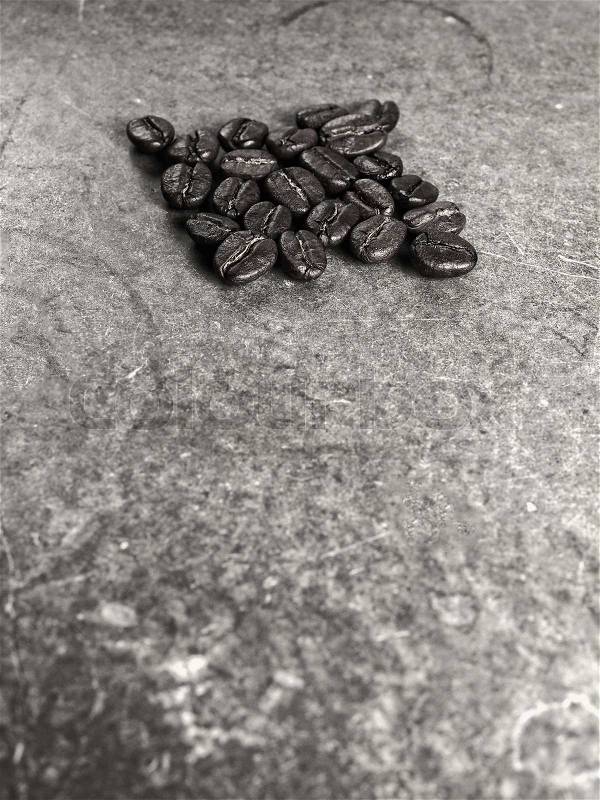 Roasted Coffee Beans on retro texture board background, monotone color, stock photo