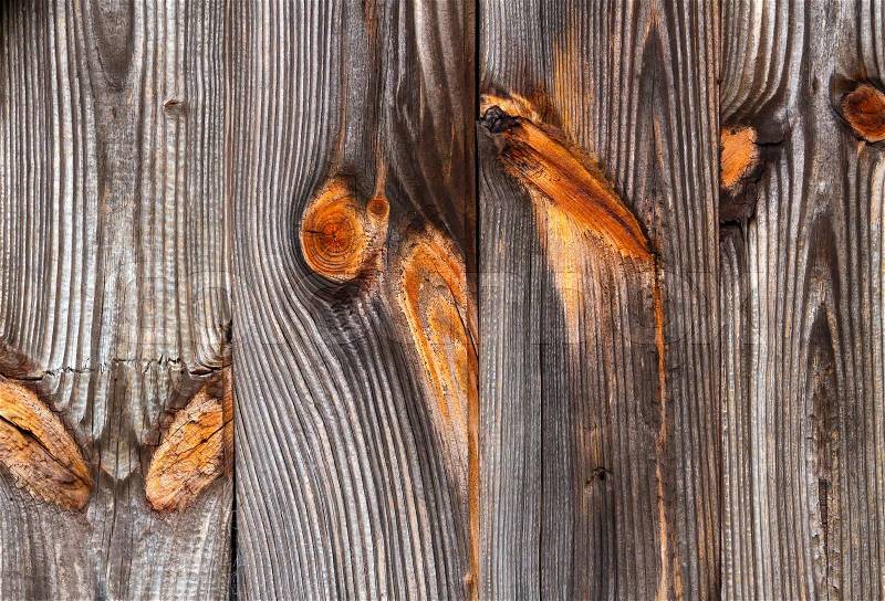 Weathered wood siding on an old building shows beautiful wood grain and colorful knots, stock photo
