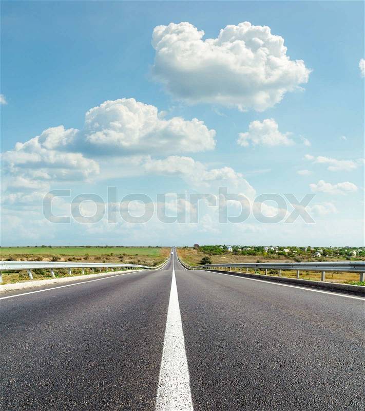 Asphalt road and clouds over it, stock photo