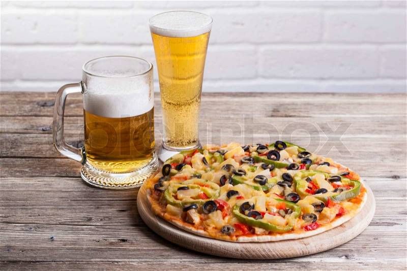 Pizza on the table with a glass of beer , stock photo
