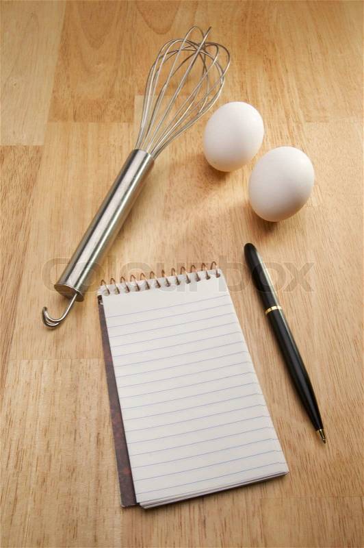 Mixer, Eggs, Pen and Pad of Paper on a wood background, stock photo