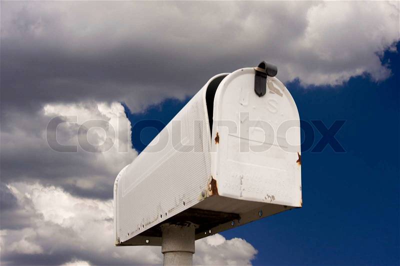 Weathered Old Mailbox Against Blue Sky and Clouds, stock photo