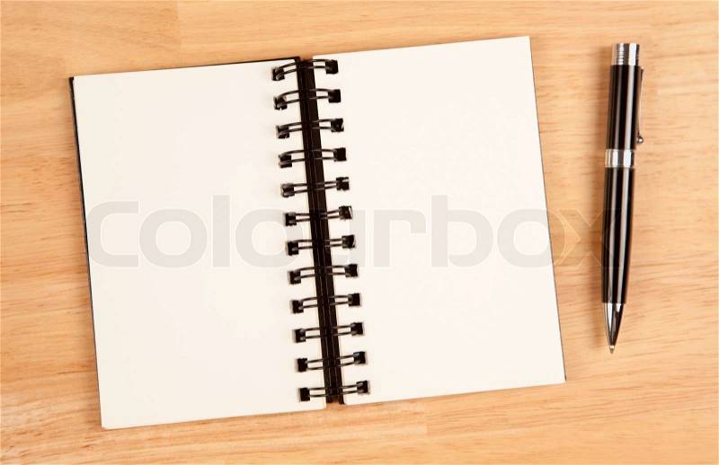 Blank Spiral Note Pad and Pen on Wood Background, stock photo