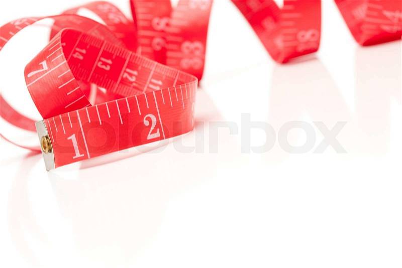 Red Measuring Tape Isolated on a White Reflective Surface, stock photo