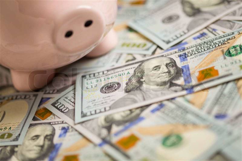 Piggy Bank on Stacks of Newly Designed One Hundred Dollar Bills, stock photo