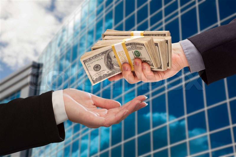 Male Hand Handing Stack of Cash to Woman with Corporate Building, stock photo