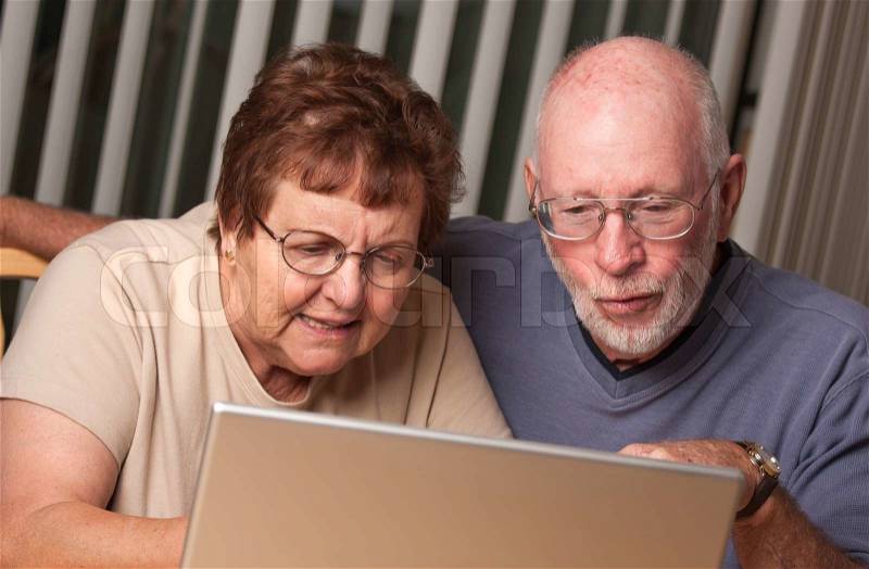 Smiling Senior Adult Couple Having Fun on the Computer Laptop Together, stock photo