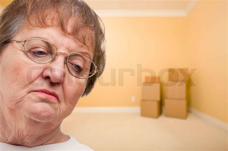 Sad Older Woman In Empty Room with Boxes - Concept for Foreclosure, Diviorce, Moving, etc, stock photo
