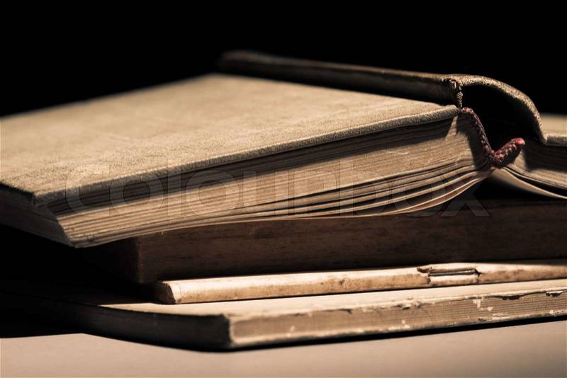 Aged book on a pile of old documents, stock photo