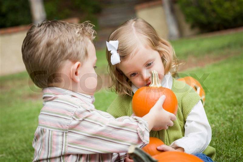 Cute Young Brother and Sister Children Enjoying the Pumpkins at the Pumpkin Patch, stock photo