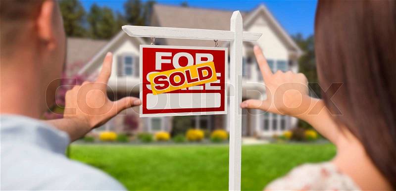Sold For Sale Real Estate Sign, House and Military Couple Framing Hands in Front, stock photo