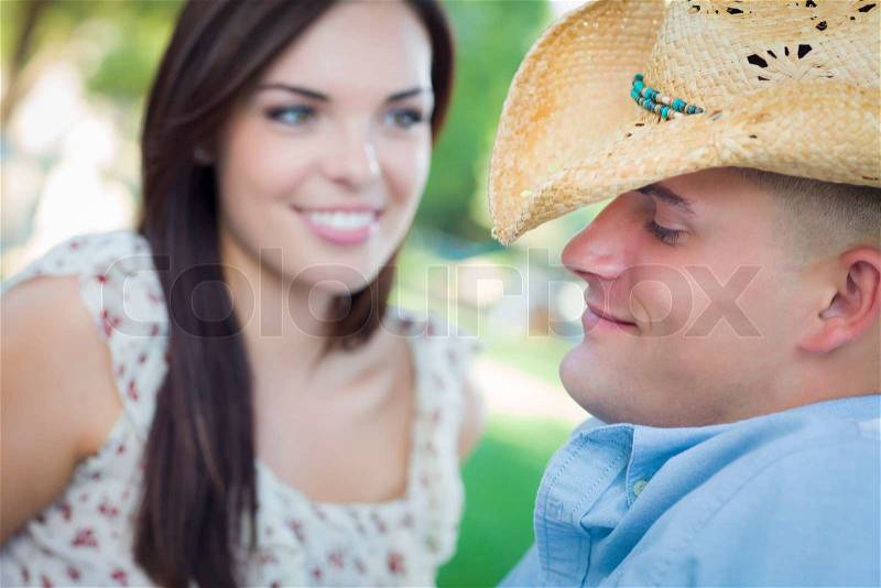 Happy Mixed Race Romantic Couple with Cowboy Hat Flirting in the Park, stock photo