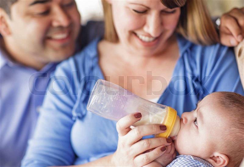 Happy Attractive Mixed Race Couple Bottle Feeding Their Son, stock photo