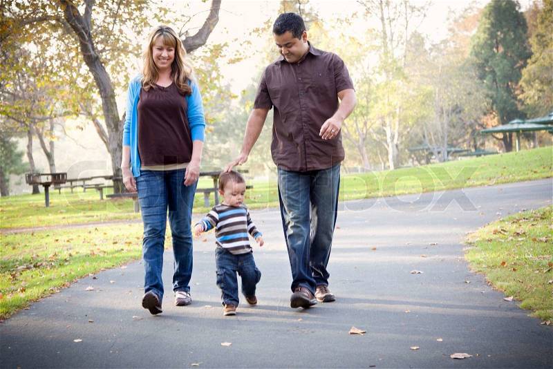 Happy Young Mixed Race Ethnic Family Walking In The Park, stock photo