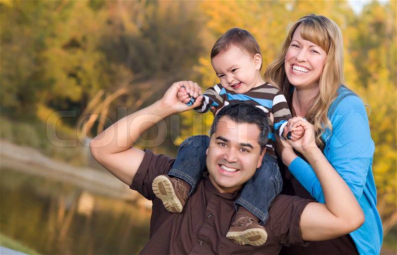 Happy Mixed Race Ethnic Family Posing for A Portrait in the Park, stock photo