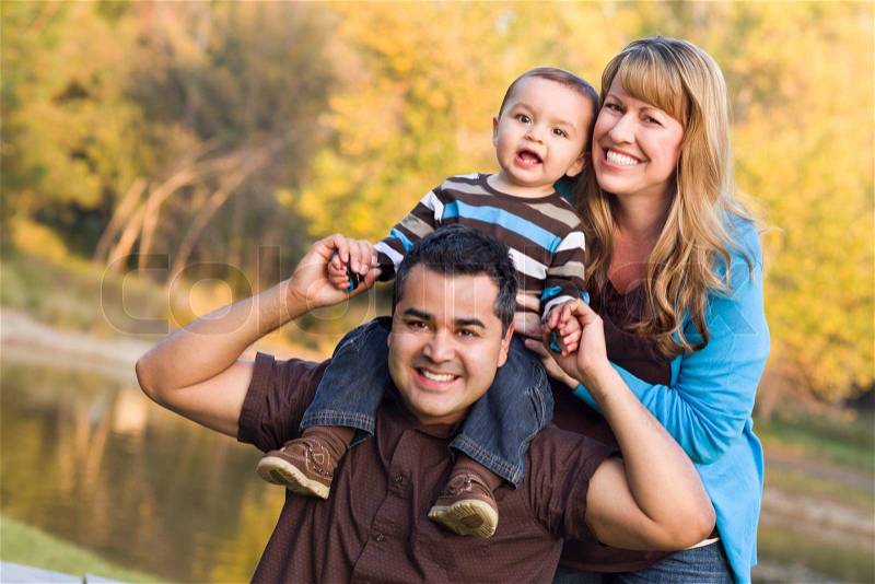 Happy Mixed Race Ethnic Family Posing for A Portrait in the Park, stock photo