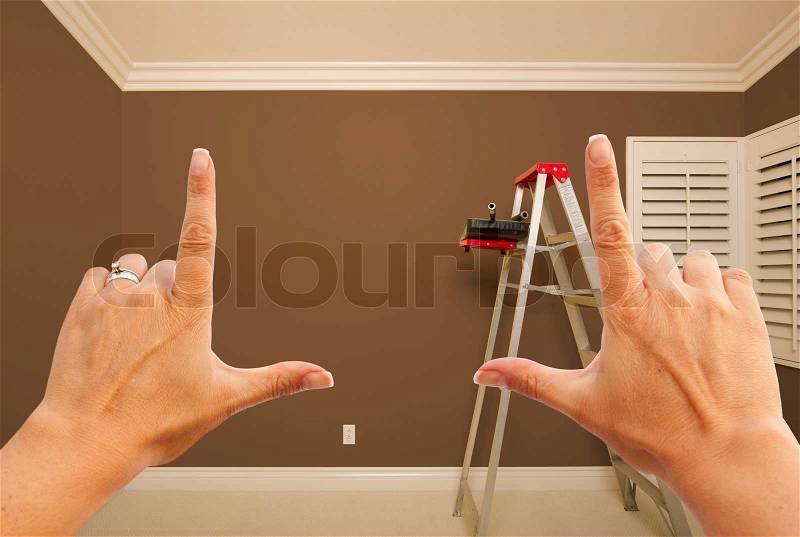 Hands Framing Brown Painted Room Wall Interior with Ladder, Paint Bucket and Rollers, stock photo