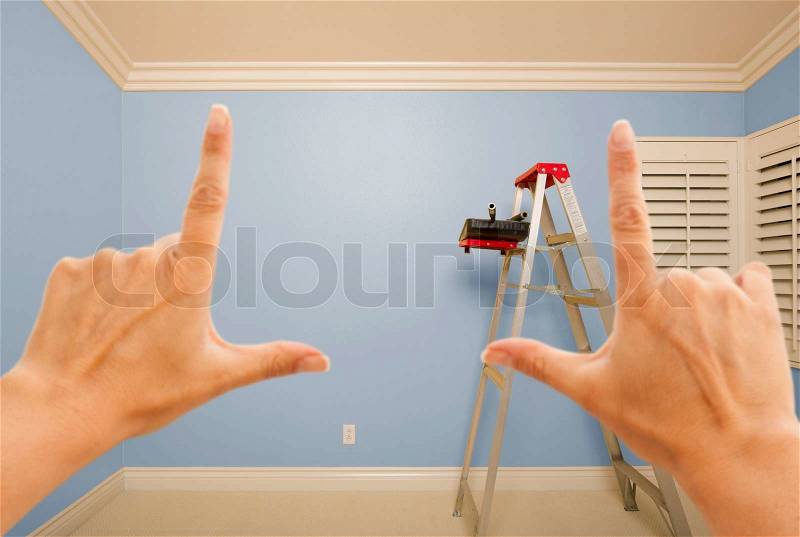 Hands Framing Blue Painted Room Wall Interior with Ladder, Paint Bucket and Rollers, stock photo