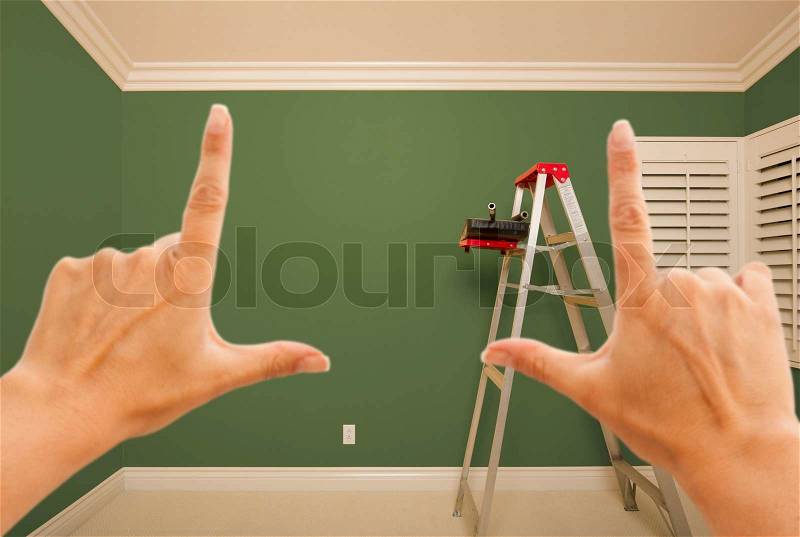 Hands Framing Green Painted Room Wall Interior with Ladder, Paint Bucket and Rollers, stock photo