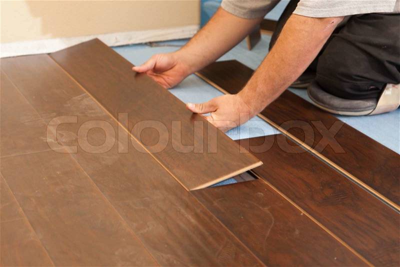 Man Installing New Laminate Wood Flooring Abstract, stock photo