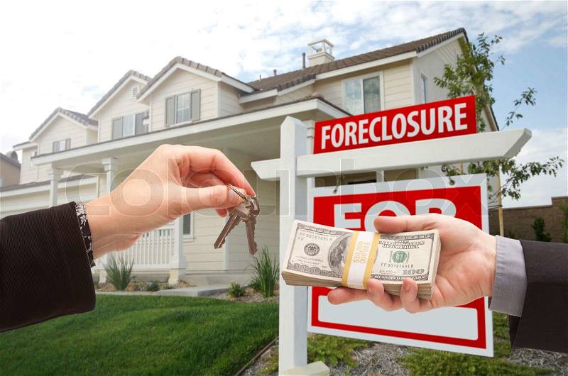 Handing Over Cash For House Keys in Front of House and Foreclosure Sign, stock photo