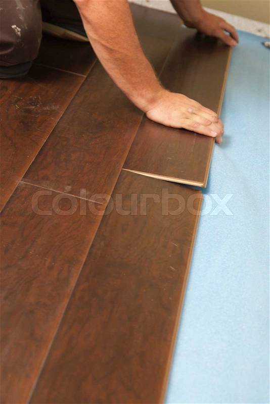 Man Installing New Laminate Wood Flooring Abstract, stock photo