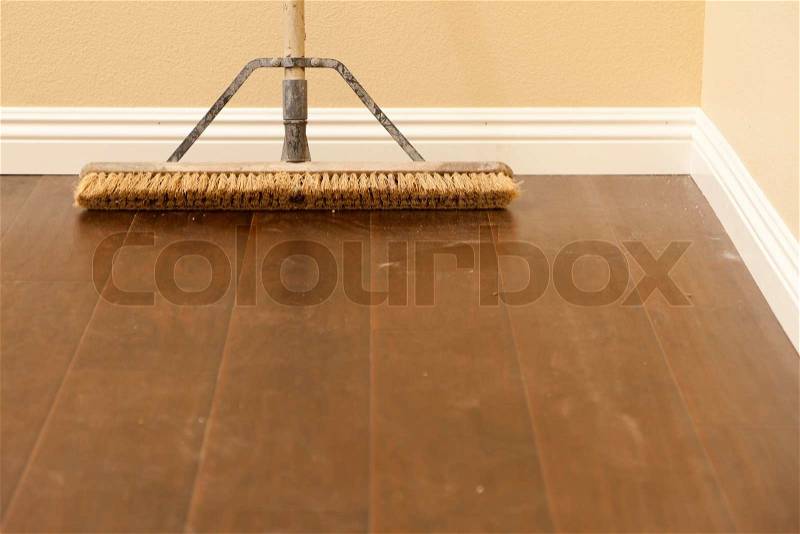 Push Broom on a Newly Installed Laminate Floor and New Baseboards, stock photo