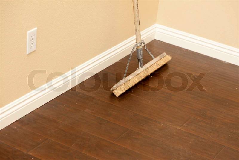 Push Broom on a Newly Installed Laminate Floor and New Baseboards, stock photo