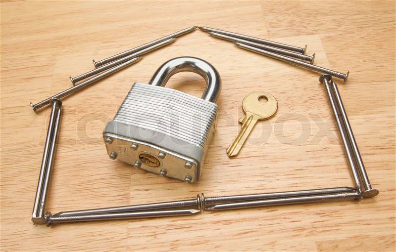 House of Nails with Lock and Key on a Wood Background, stock photo