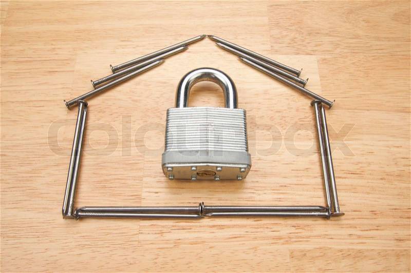 House of Nails with Lock on a Wood Background, stock photo