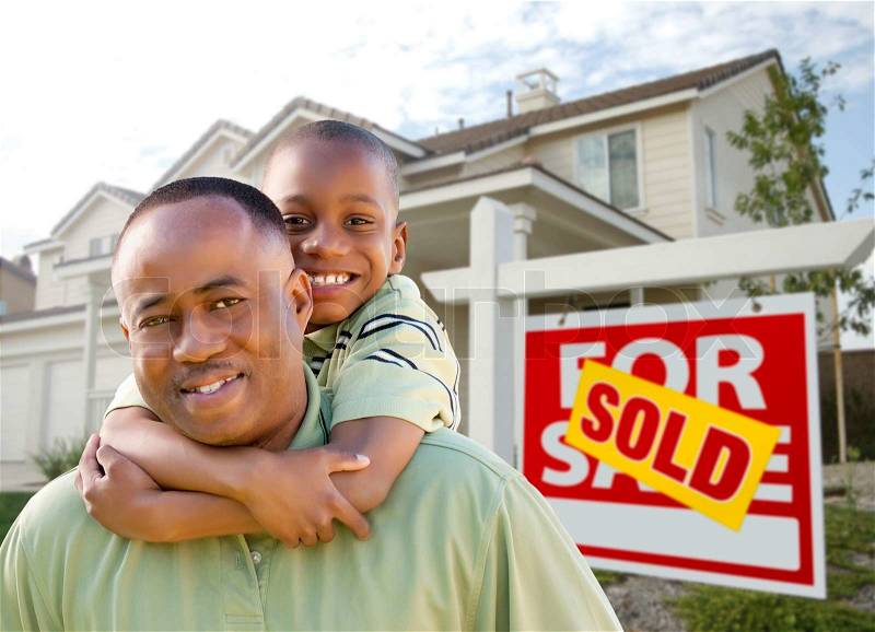 Happy African American Father and Son in Front of New Home and Real Estate Sign, stock photo
