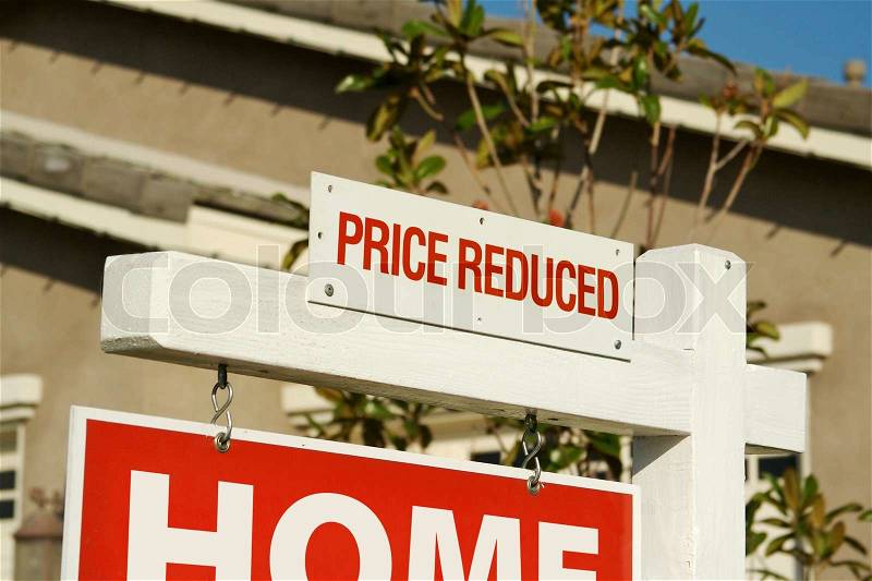 Price Reduced Real Estate Sign in Front of Beautiful New Home, stock photo