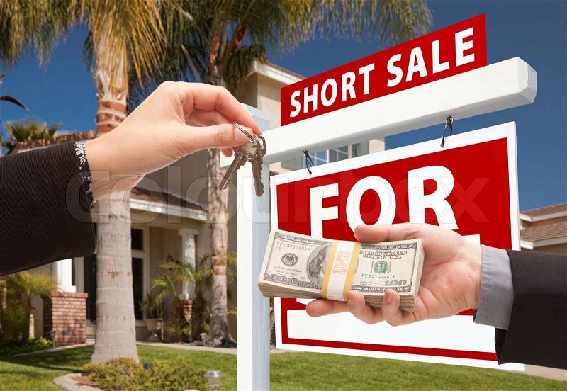 Handing Over Cash For House Keys and Short Sale Real Estate Sign in Front of Home, stock photo