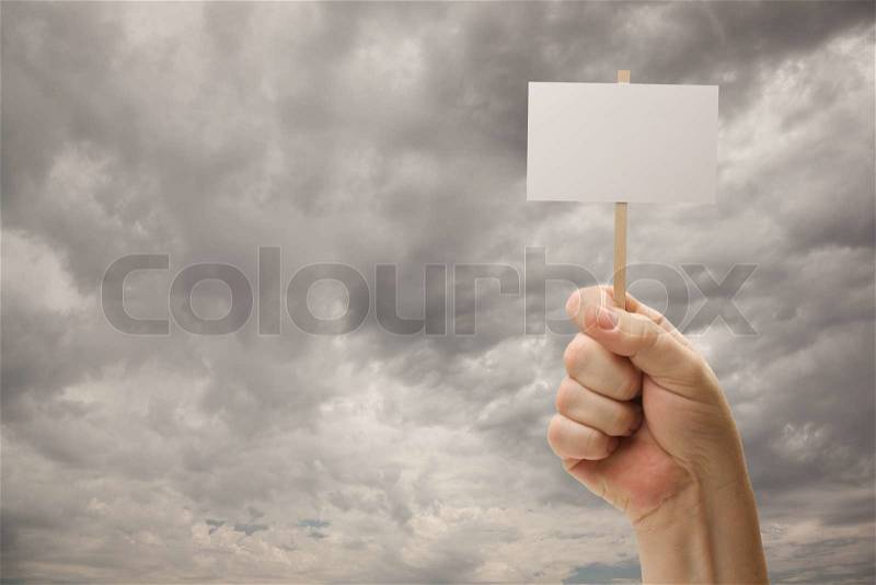 Man Holding Blank Sign Over Dramatic Storm Cloudy Sky - Ready For Your Own Message on Sign and Over Clouds, stock photo