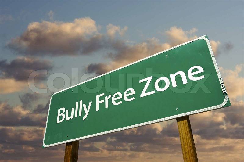 Bully Free Zone Green Road Sign In Front of Dramatic Clouds and Sky, stock photo