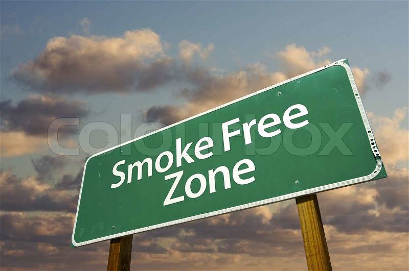 Smoke Free Zone Green Road Sign In Front of Dramatic Clouds and Sky, stock photo