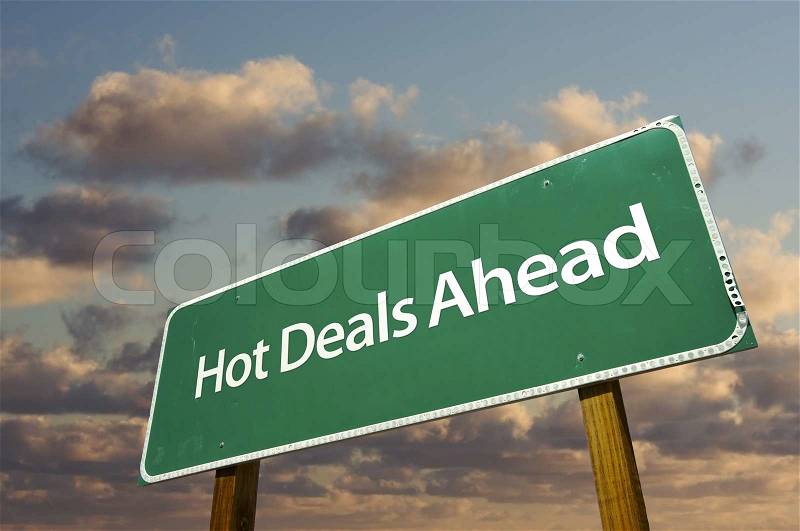 Hot Deals Ahead Green Road Sign Over Dramatic Clouds and Sky, stock photo