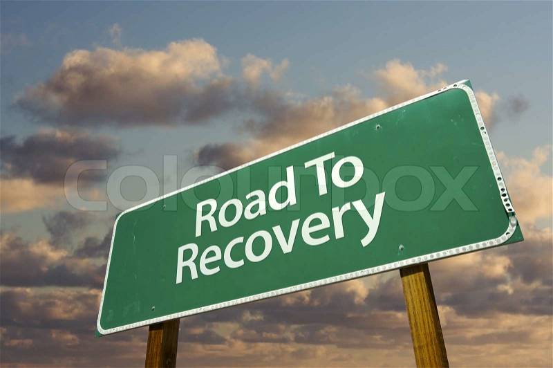 Road To Recovery Green Road Sign with dramatic clouds and sky, stock photo