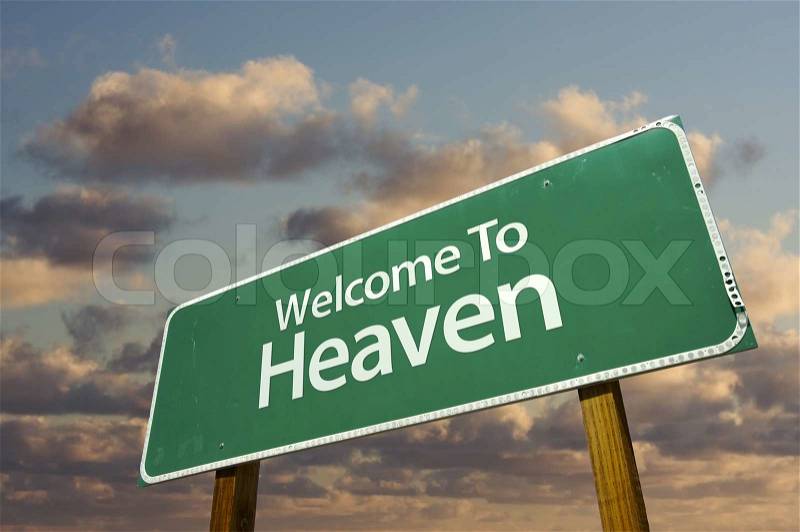 Welcome To Heaven Green Road Sign with dramatic clouds and sky, stock photo