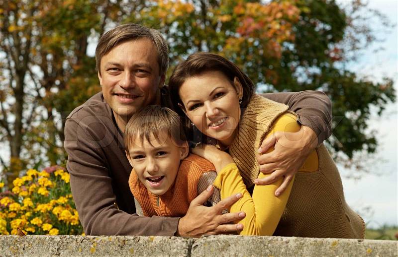 Family on a walk during the fall of the leaves in the park, stock photo