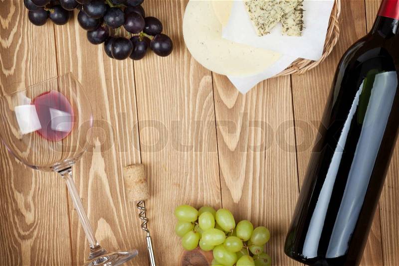 Red wine, cheese and grape on wooden table background with copy space, stock photo