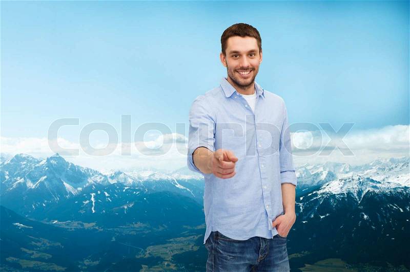 Happiness and people concept - smiling man pointing finger at you, stock photo