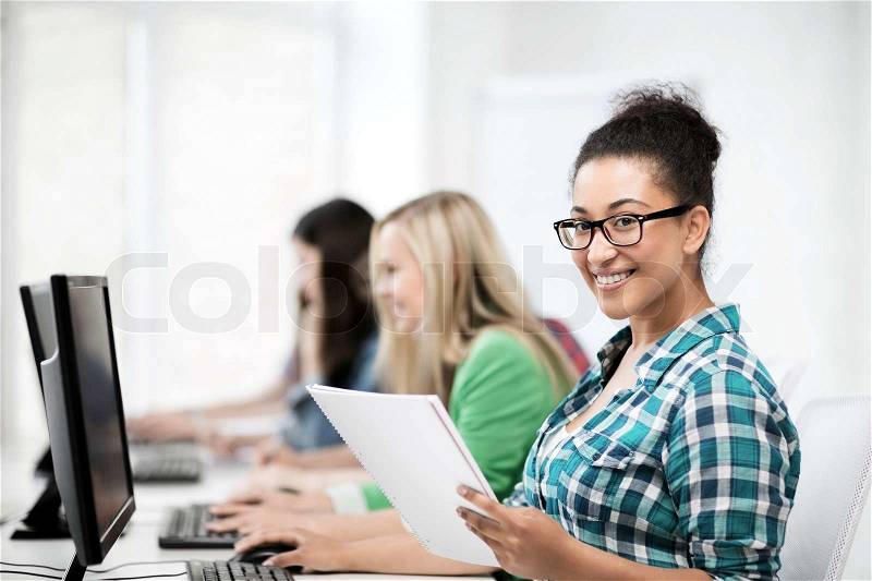 Education, technology and internet - african student with computer studying at school, stock photo